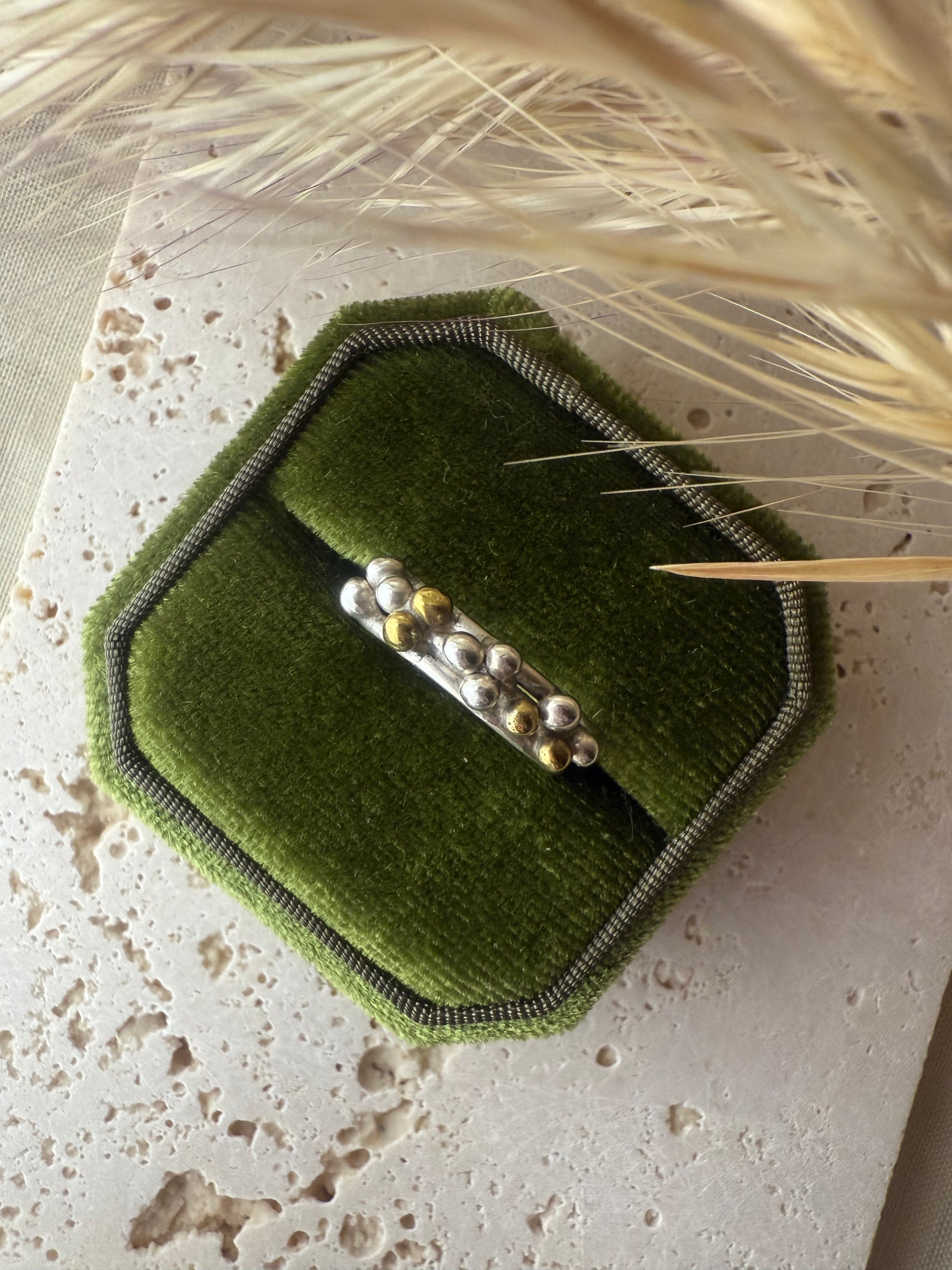 Green hexagonal jewelry box with a barrette on a textured surface