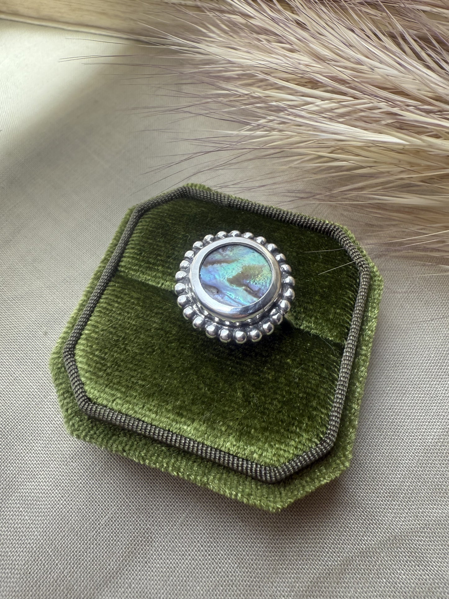Artisan abalone ring in oxidized sterling silver showing natural ocean colors.